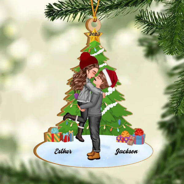 Personalisiertes Weihnachtspaar, das sich unter einem Kiefernbaum küsst und umarmt